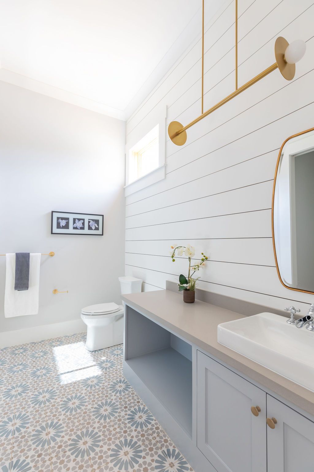 A bathroom with a sink , toilet and mirror.