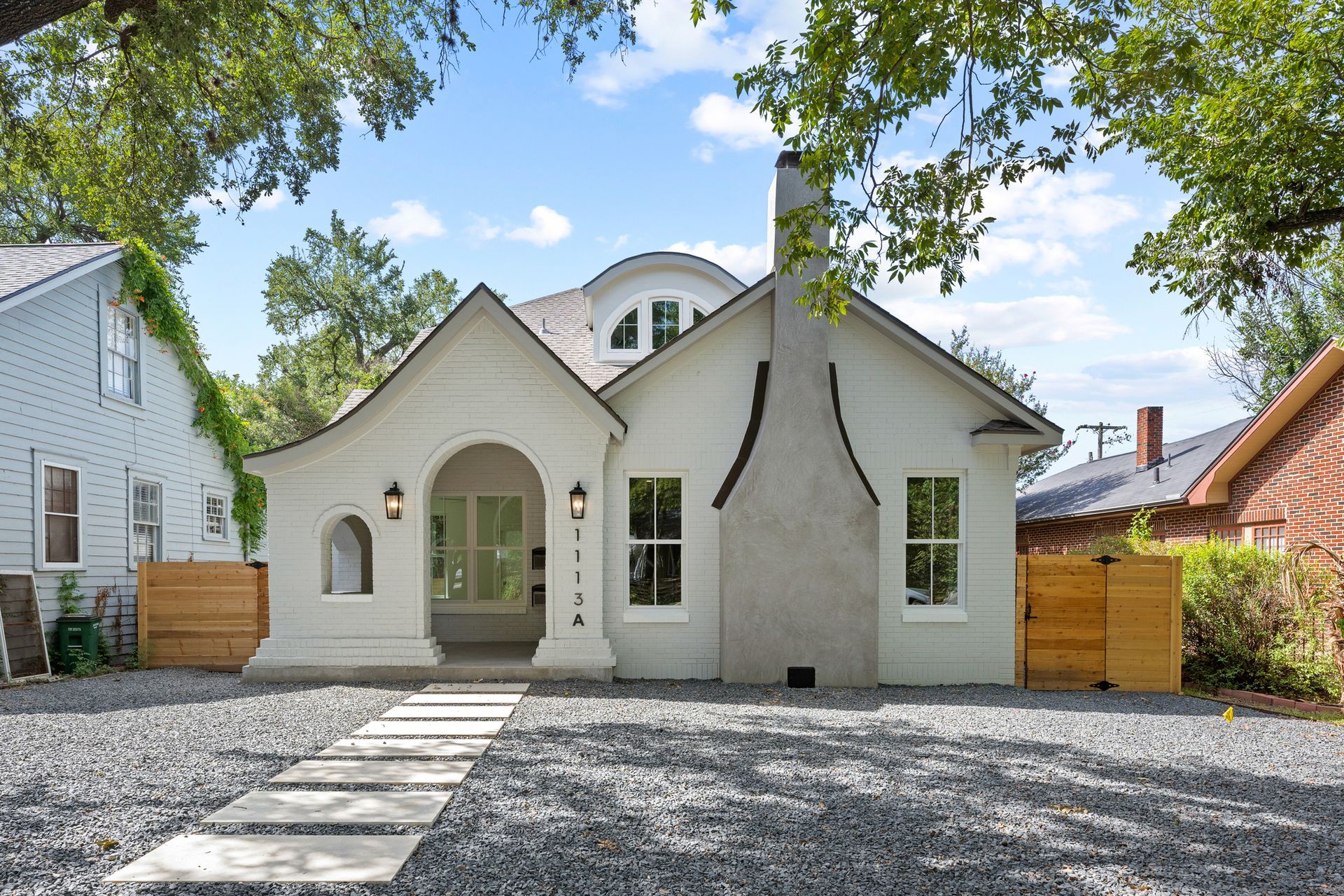 A white house with a stone walkway leading to it