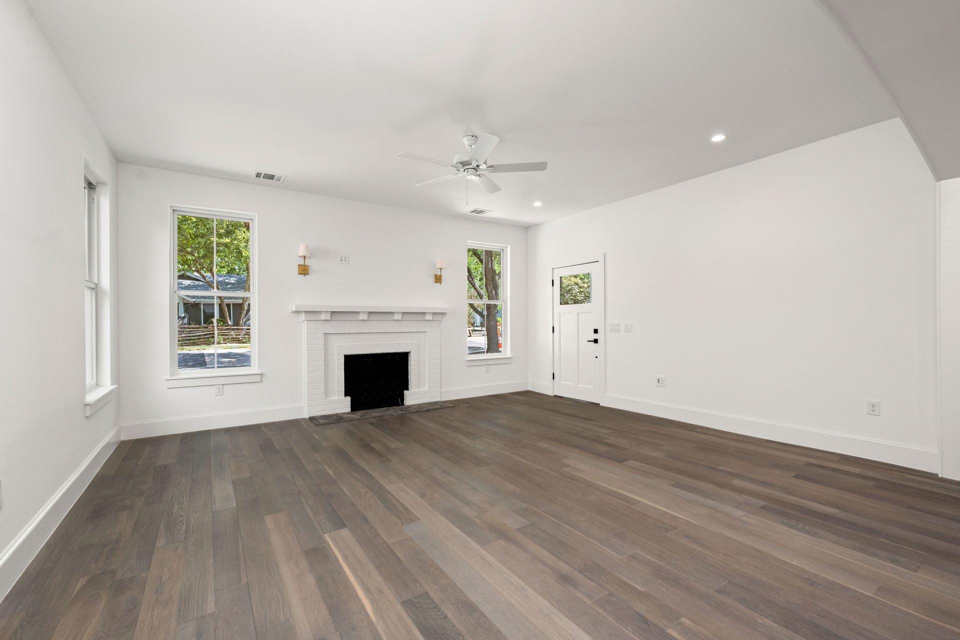 An empty living room with hardwood floors and a fireplace.