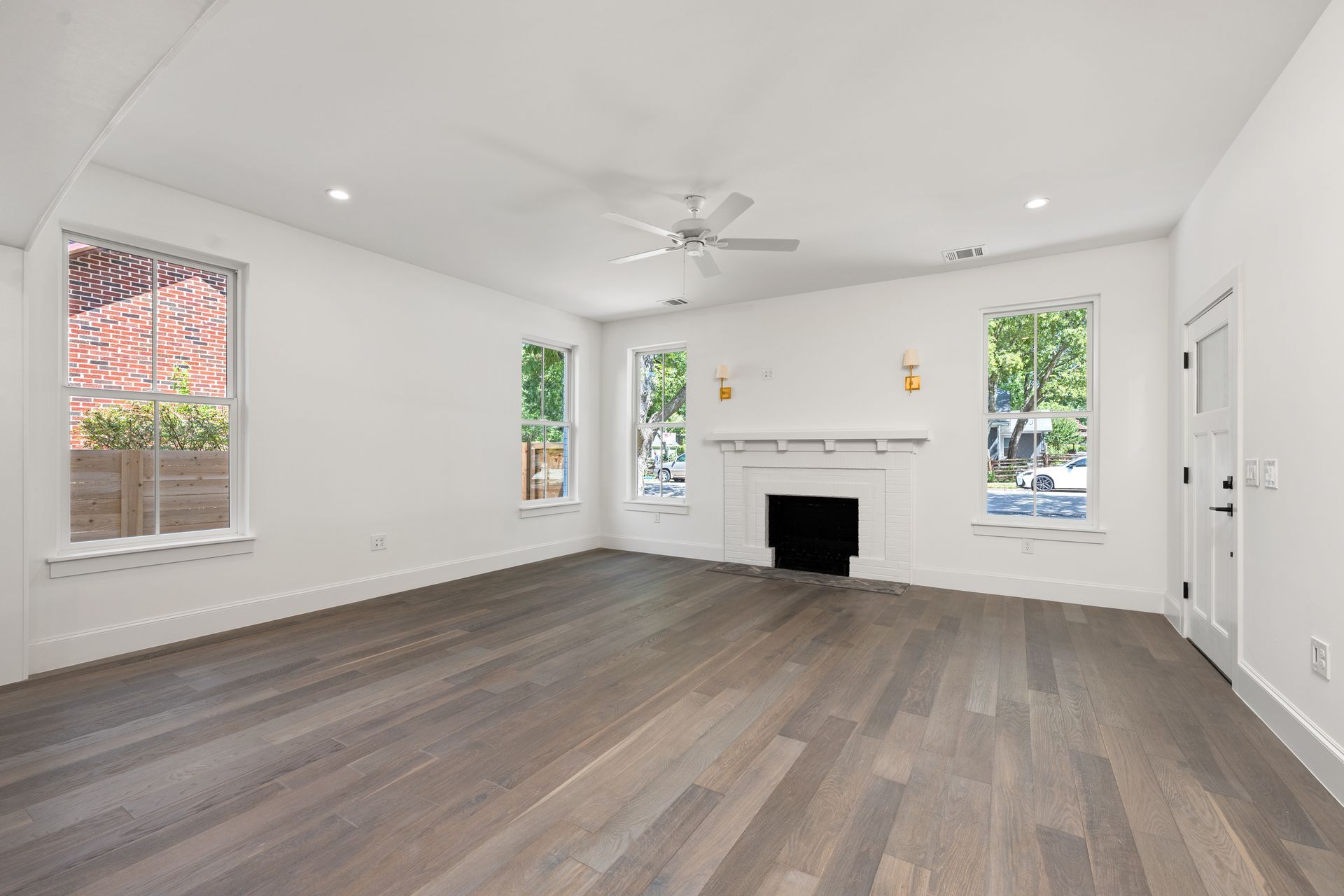 An empty living room with hardwood floors and a fireplace.