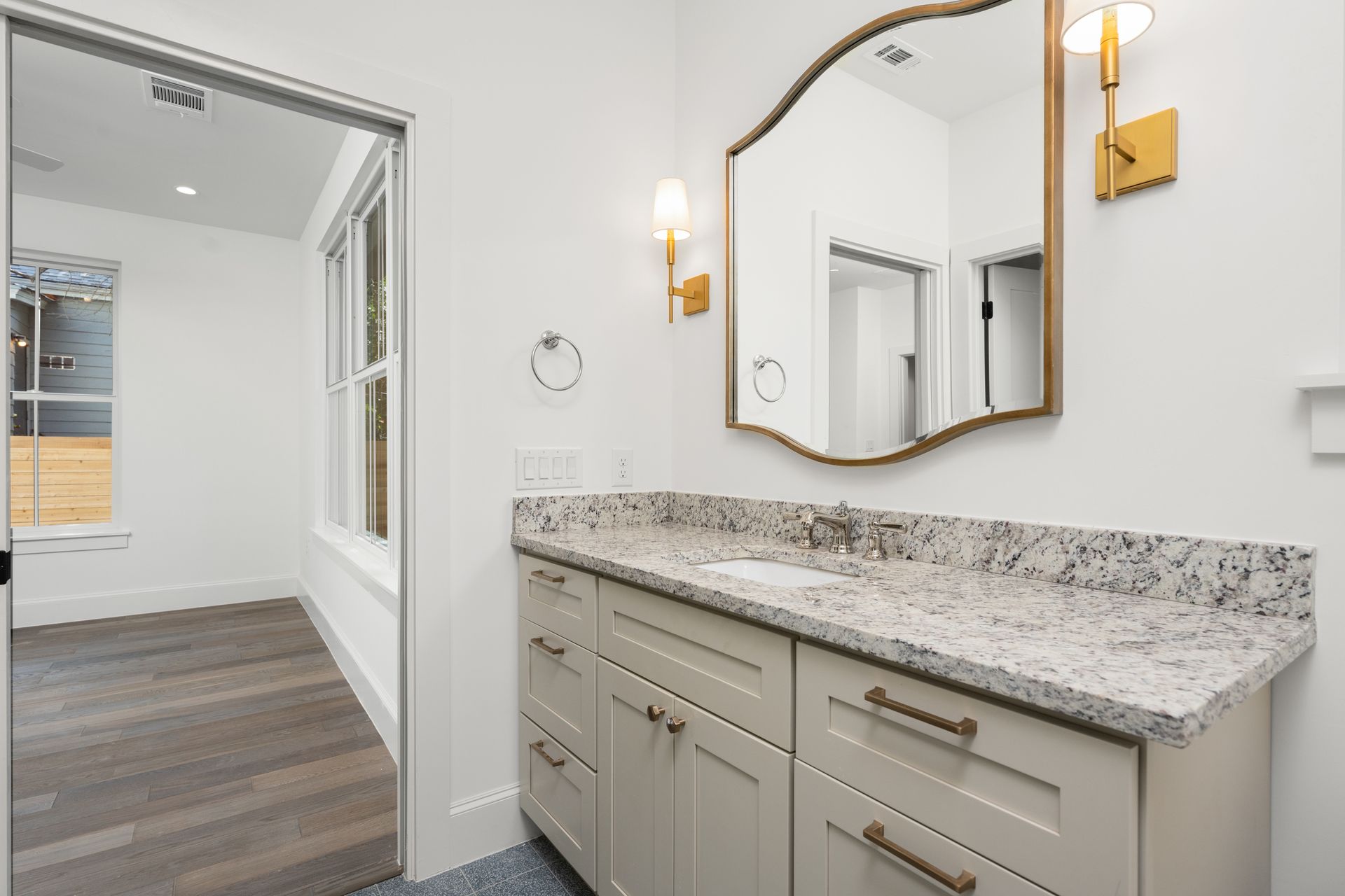 A bathroom with a sink , mirror and cabinets.