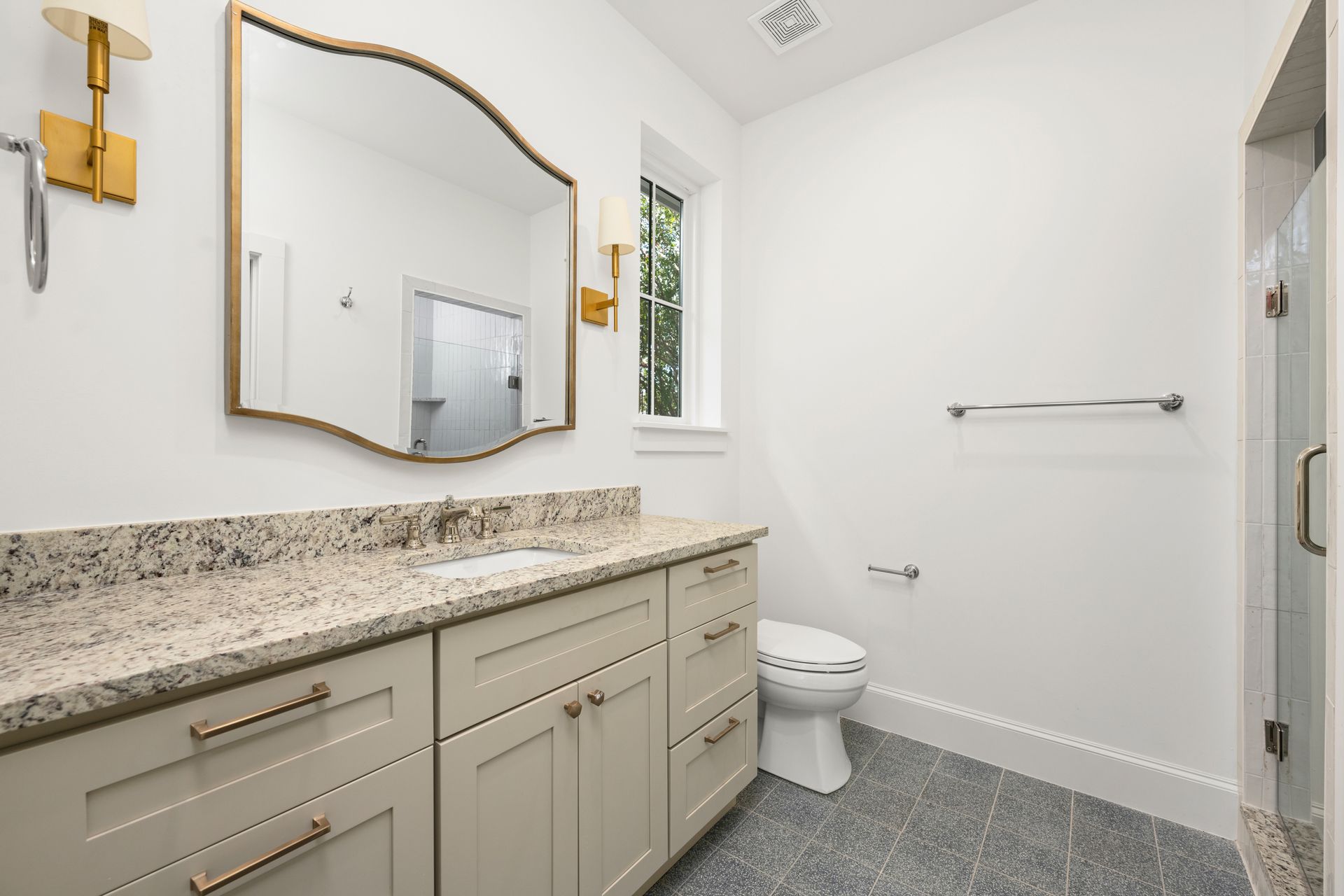 A bathroom with a toilet , sink and mirror.
