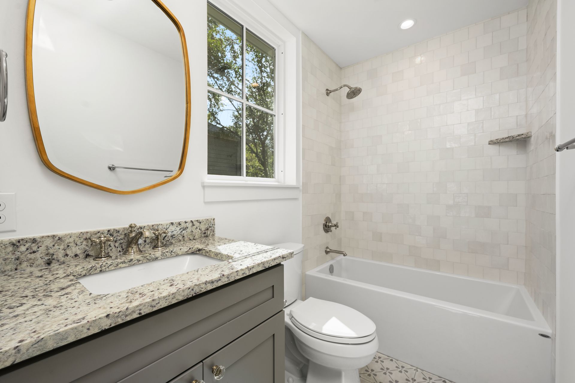 A bathroom with a toilet , sink , tub and mirror.