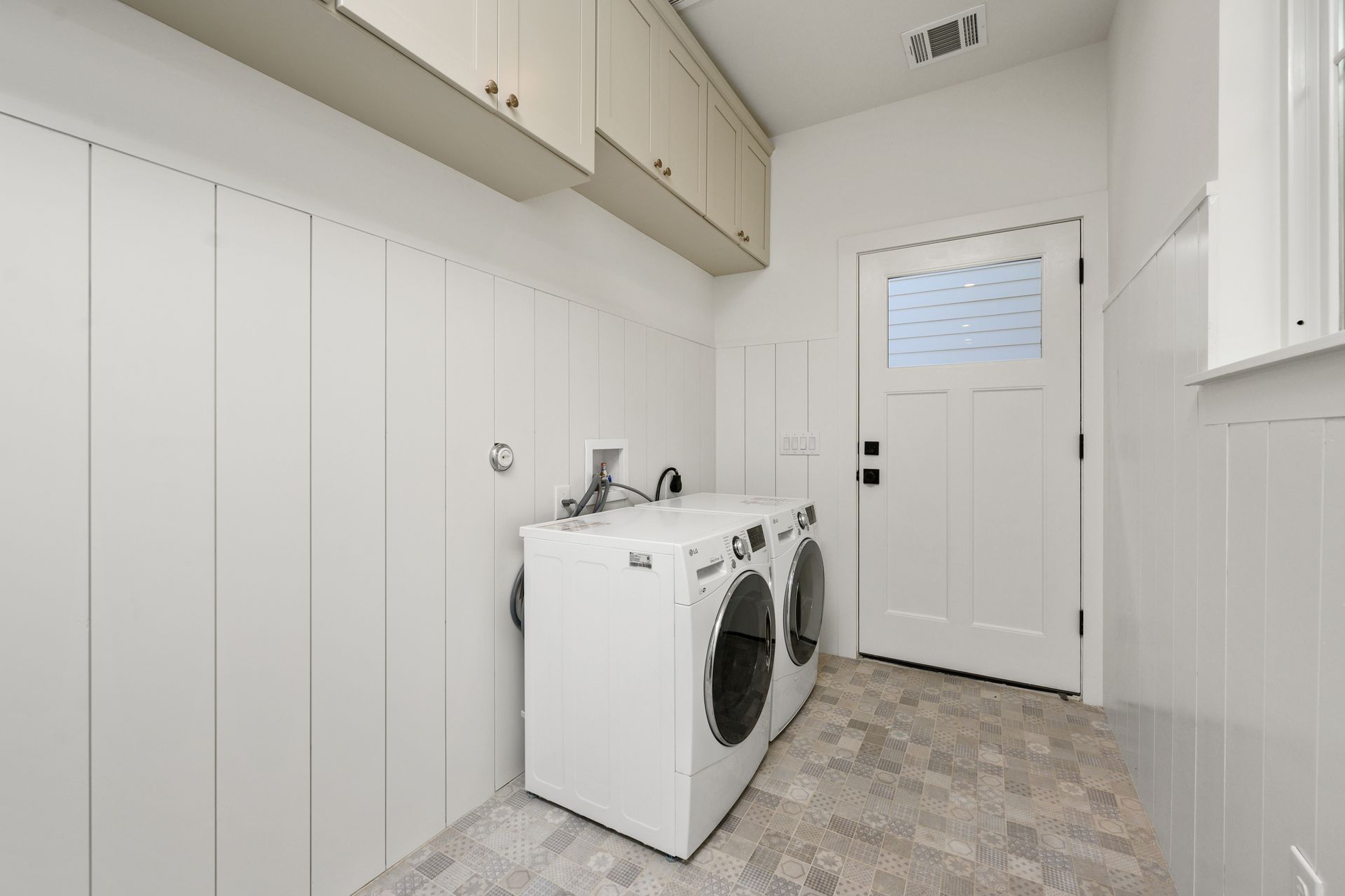 A laundry room with a washer and dryer and a door.