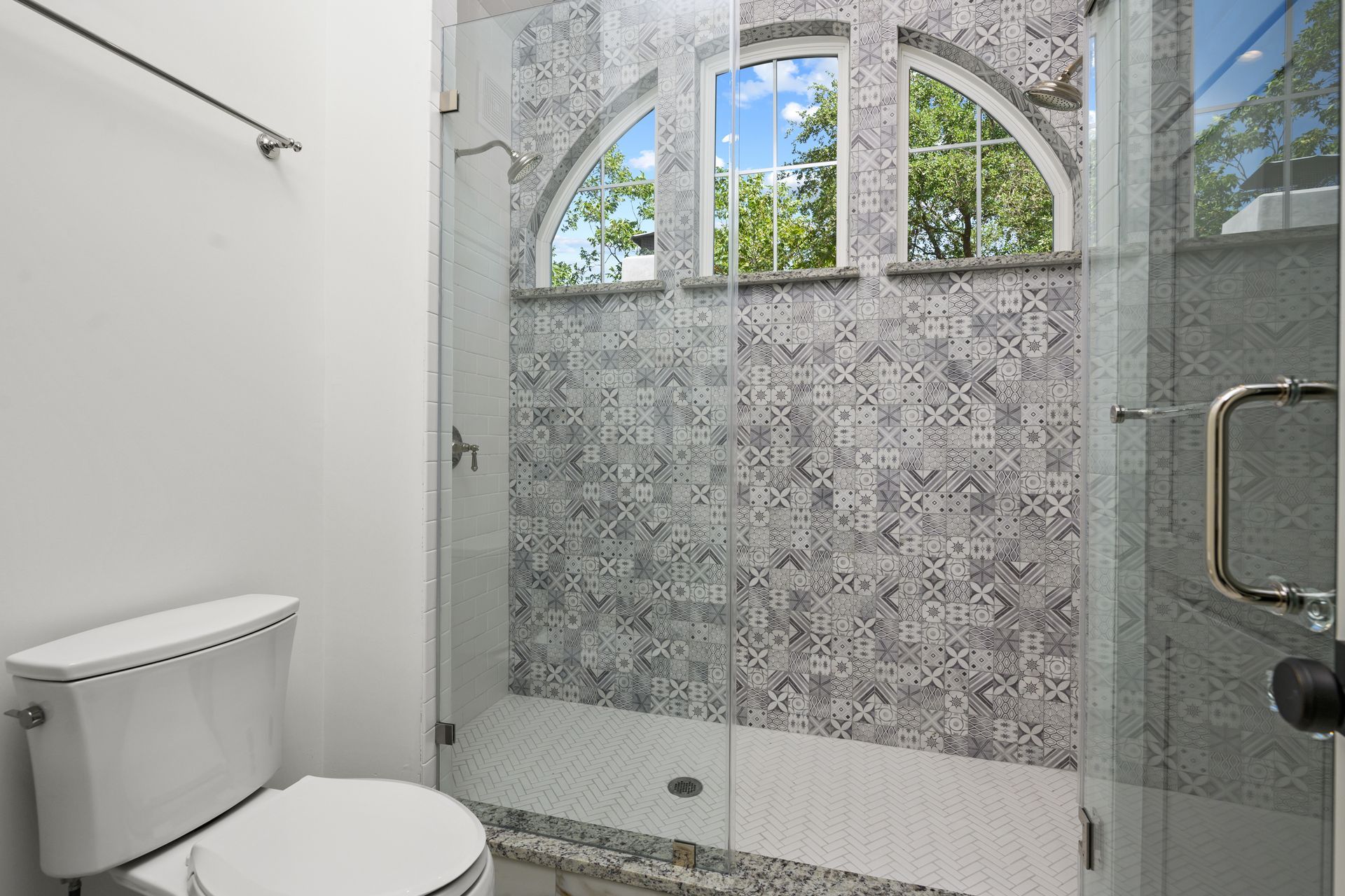 A bathroom with a toilet and a shower with a glass door.