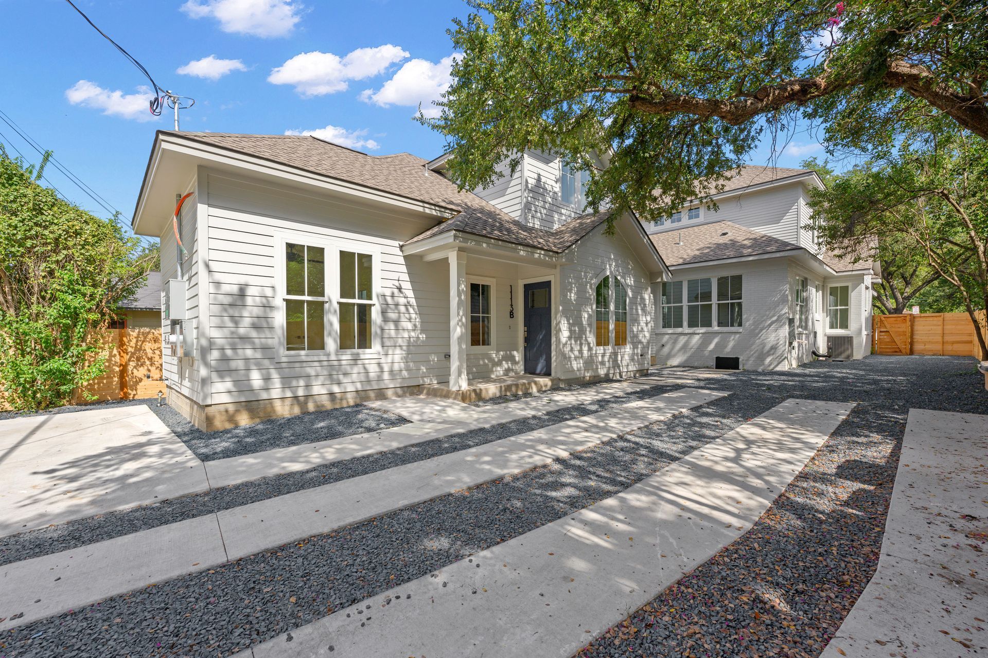 A white house with a striped driveway in front of it