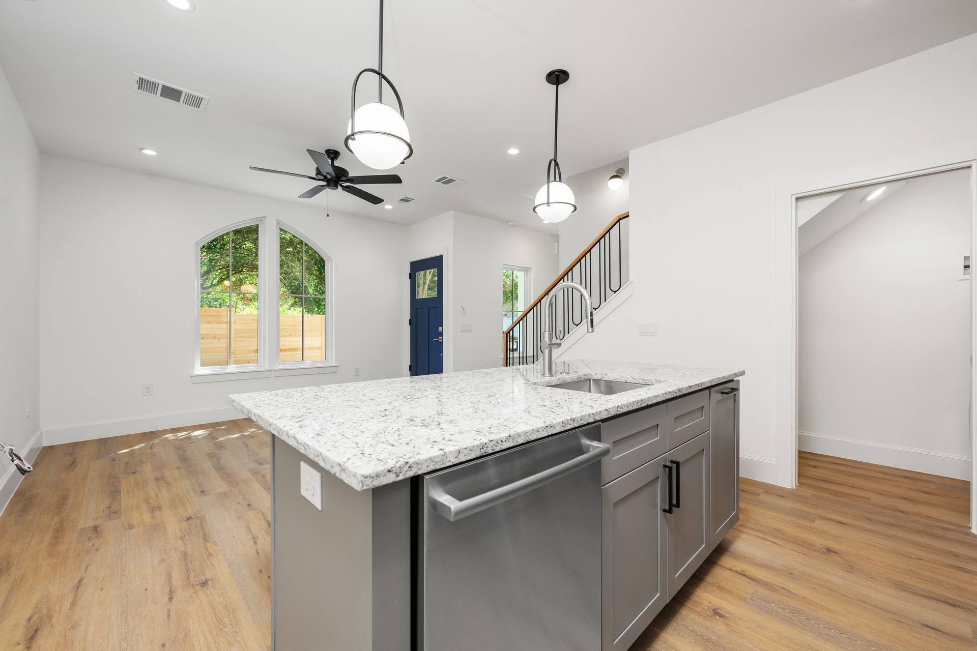 A kitchen with a large island and a stainless steel dishwasher.
