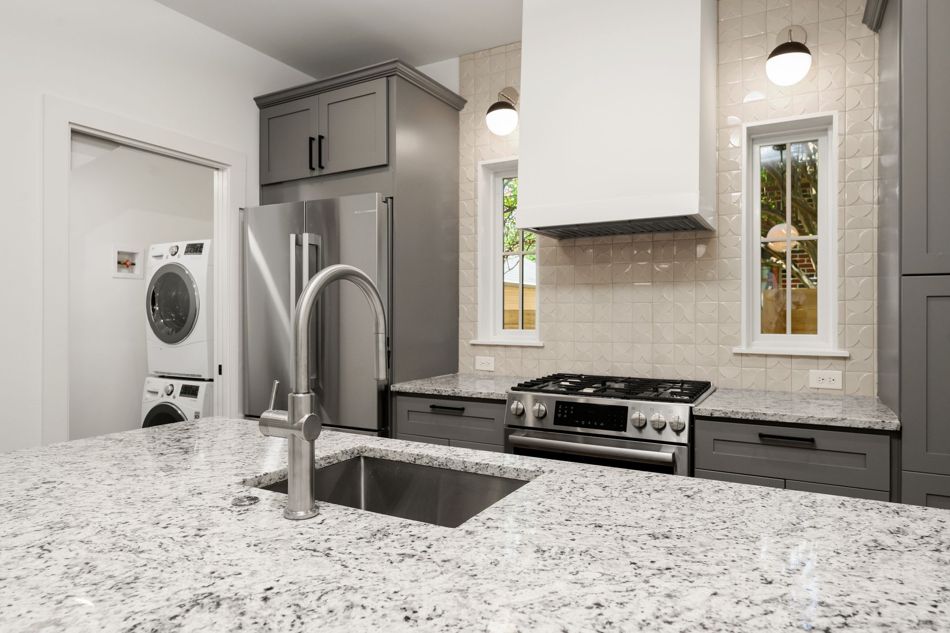 A kitchen with granite counter tops , stainless steel appliances , and a sink.