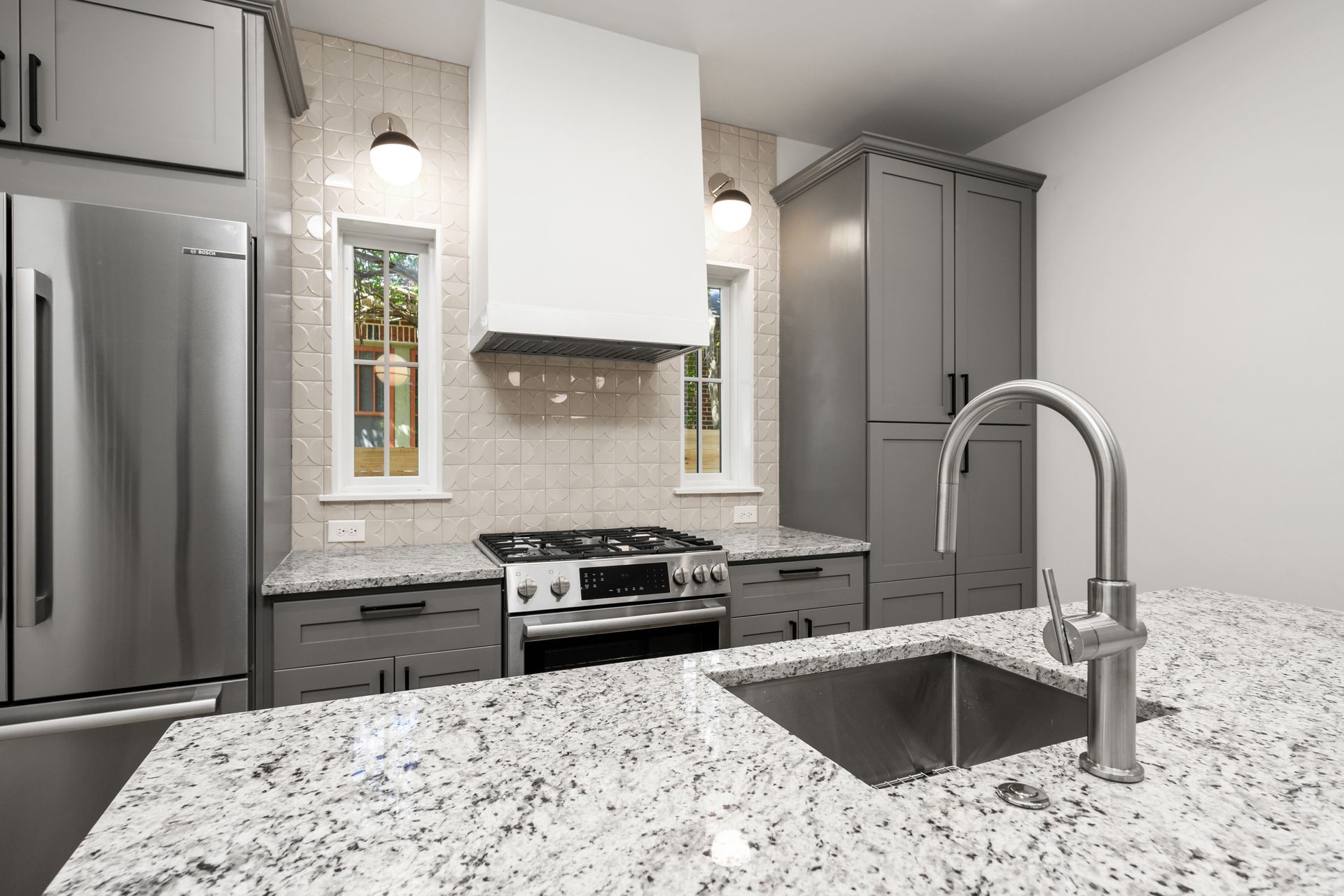 A kitchen with granite counter tops , stainless steel appliances , and a sink.