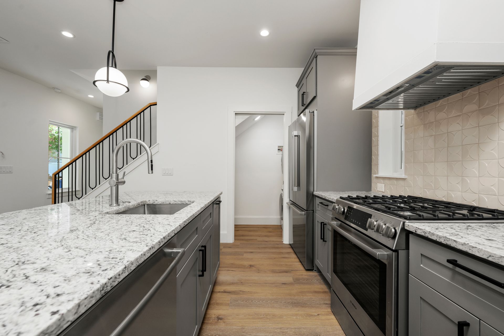 A kitchen with granite counter tops and stainless steel appliances.