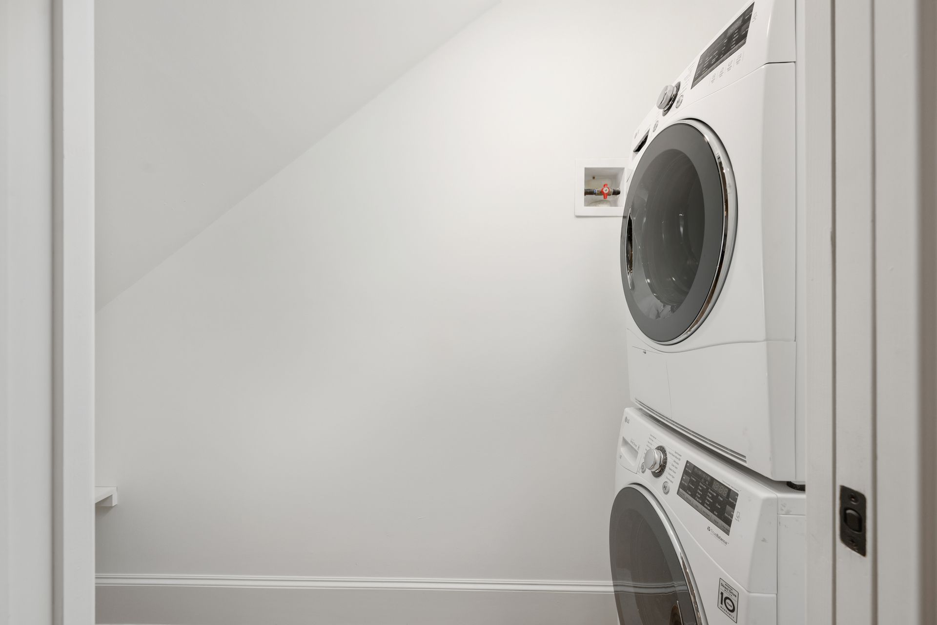 A laundry room with a washer and dryer stacked on top of each other.