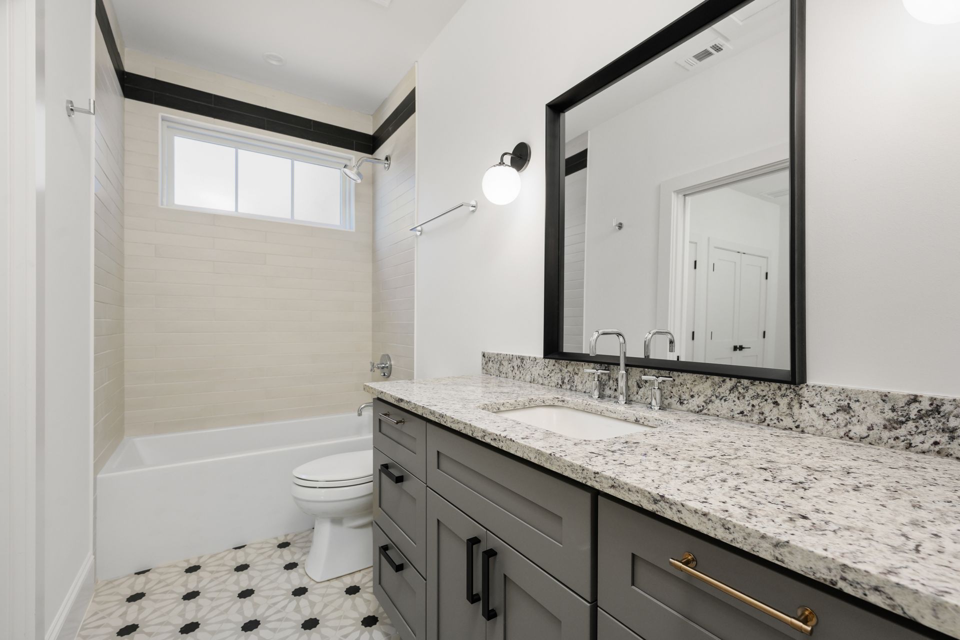 A bathroom with a sink , toilet , bathtub and mirror.