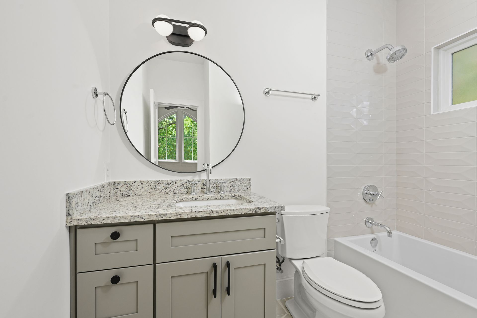 A bathroom with a sink , toilet , bathtub and mirror.