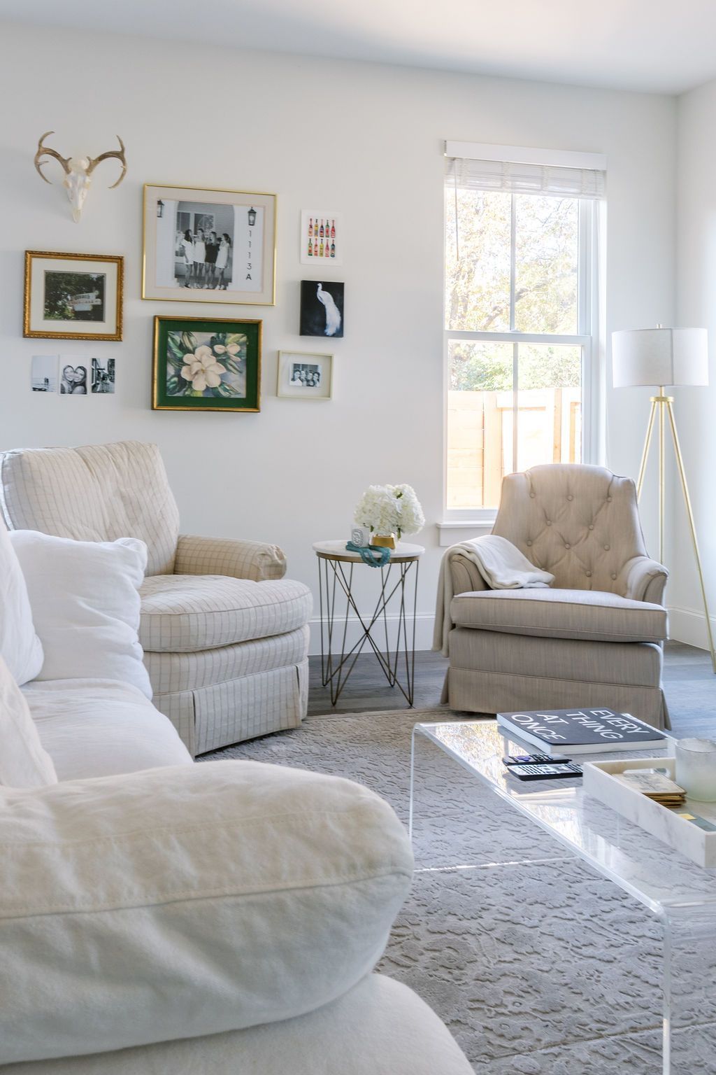 A living room with white furniture and a clear coffee table