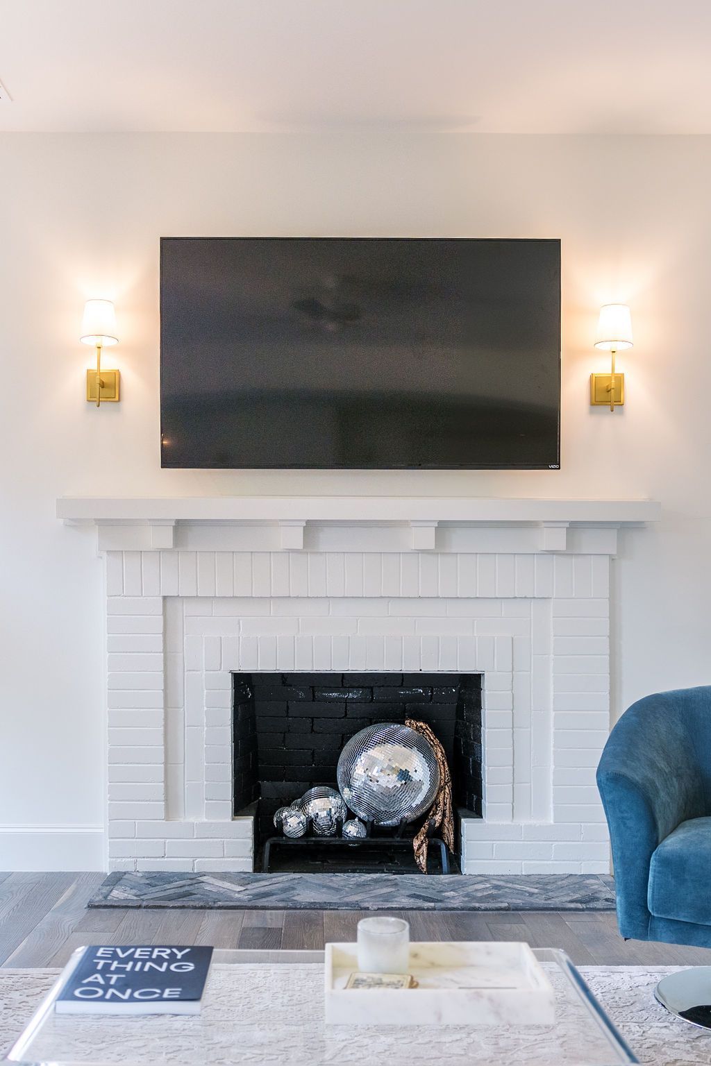 A living room with a fireplace and a flat screen tv on the wall.