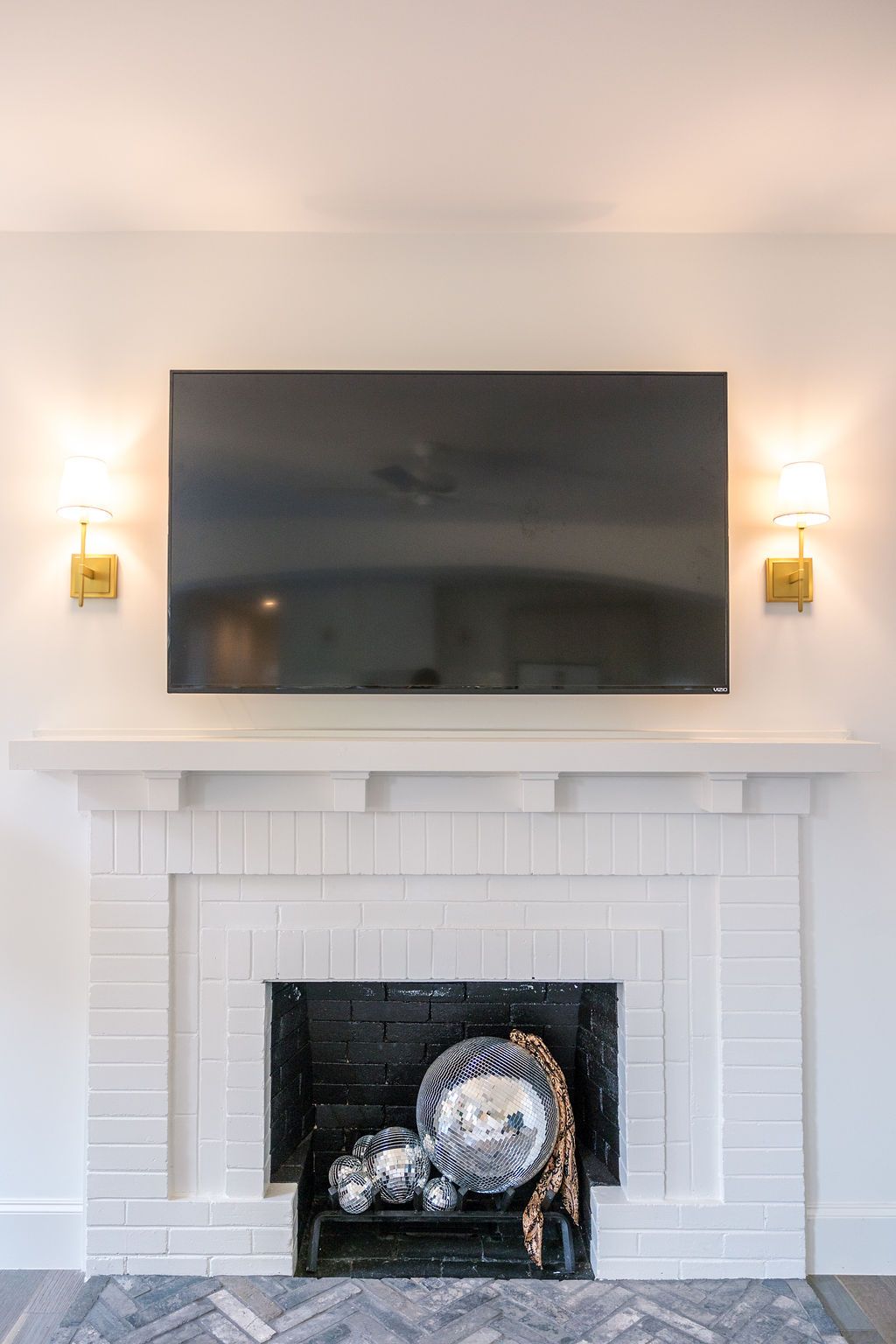 A living room with a fireplace and a flat screen tv mounted on the wall above it.