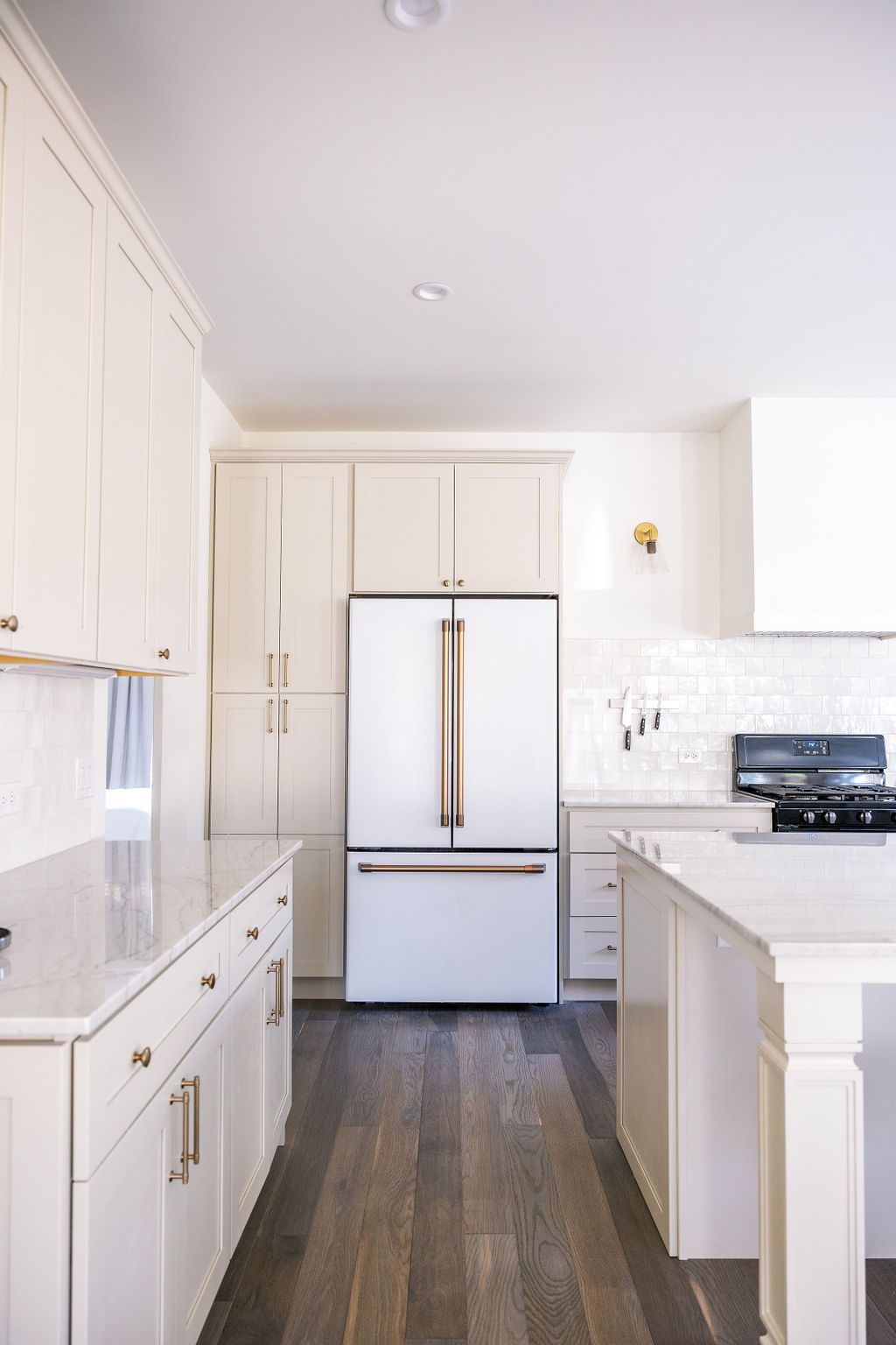 A kitchen with white cabinets and a white refrigerator.