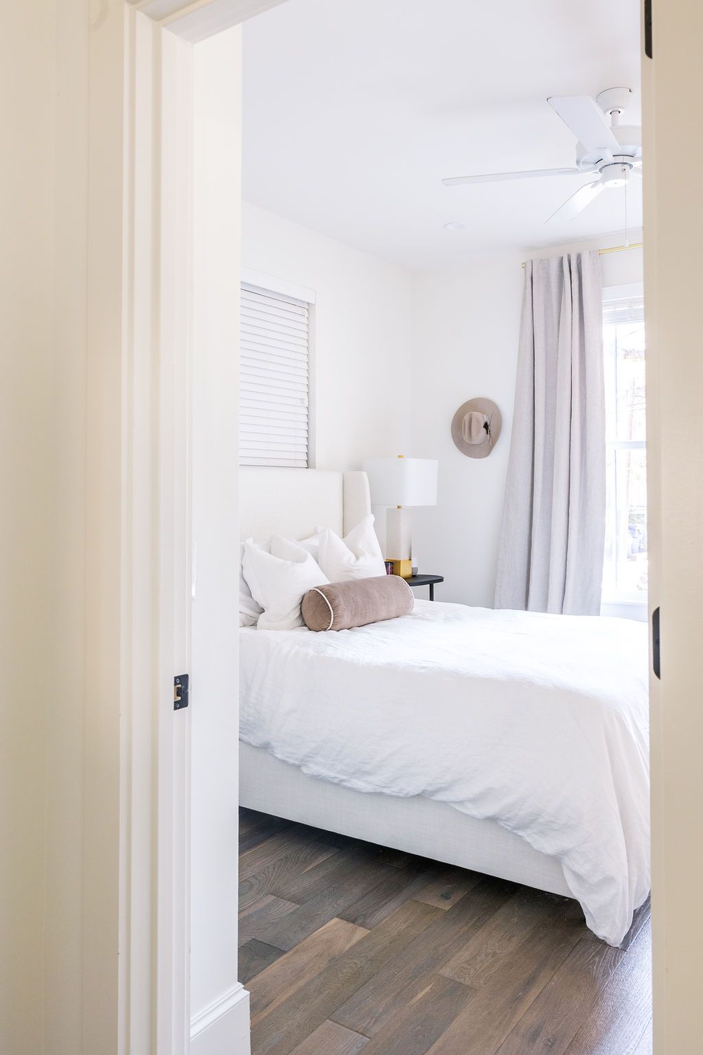 A bedroom with a large bed and a ceiling fan.