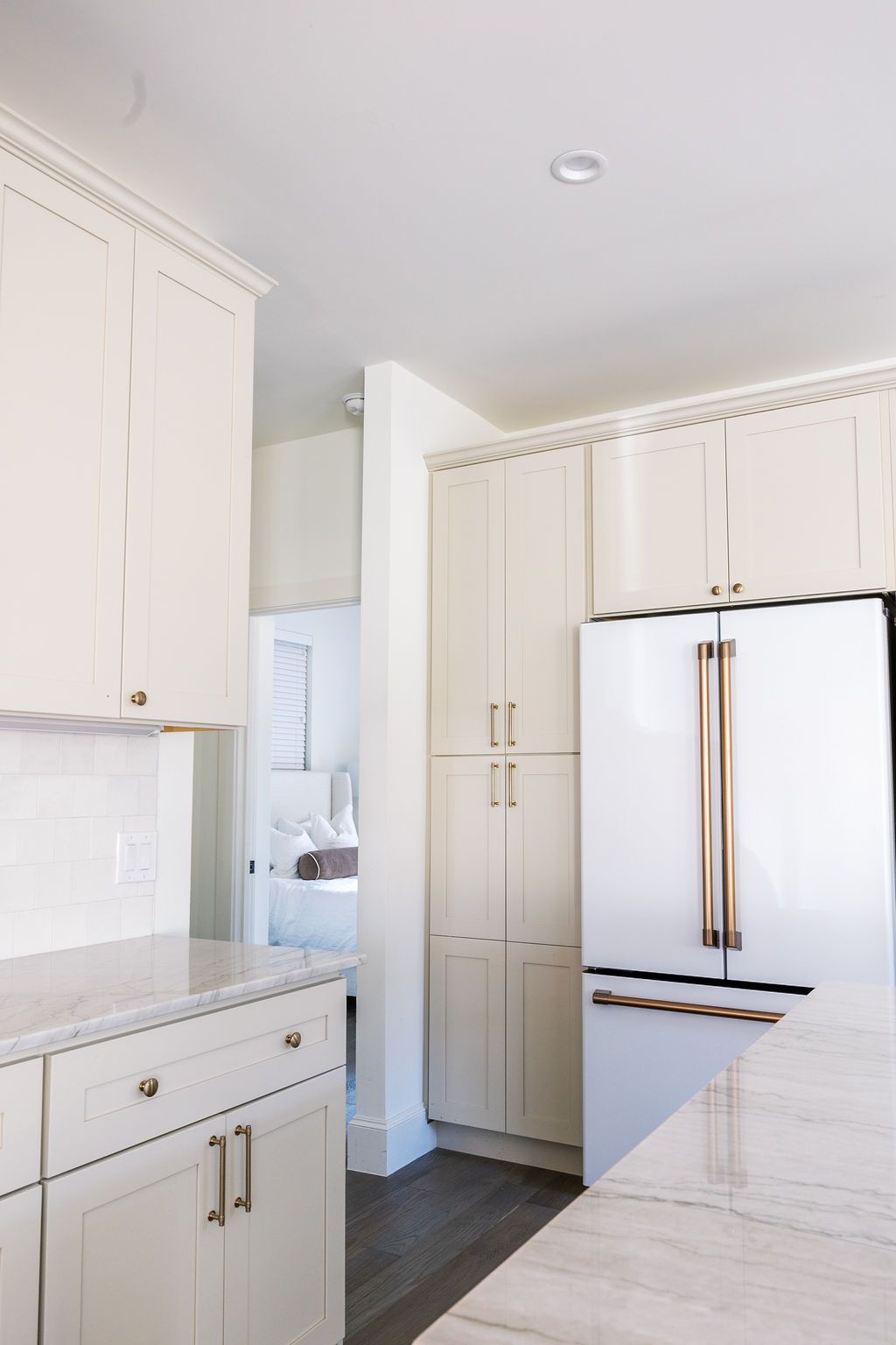 A kitchen with white cabinets and a white refrigerator