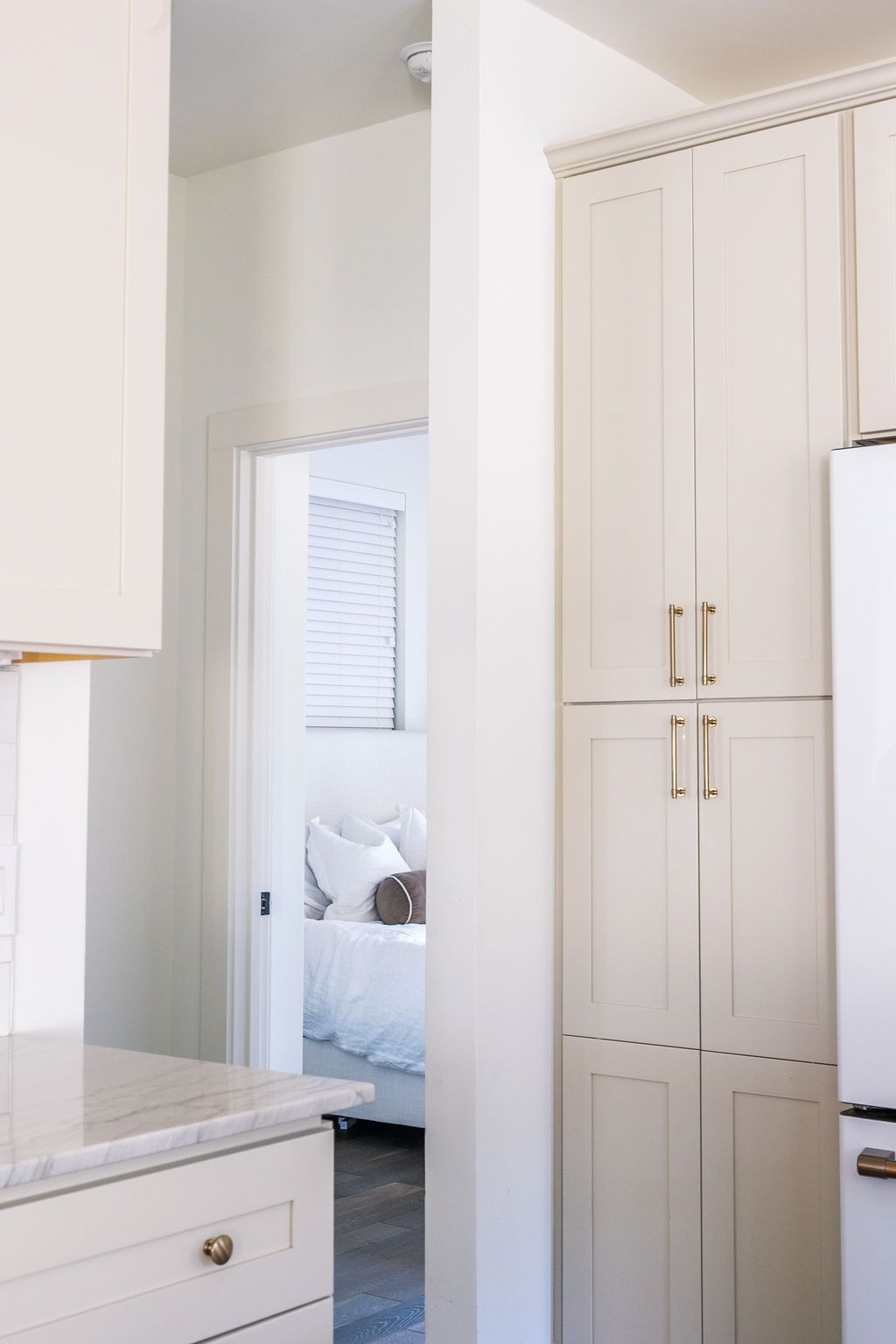A kitchen with white cabinets and a refrigerator.