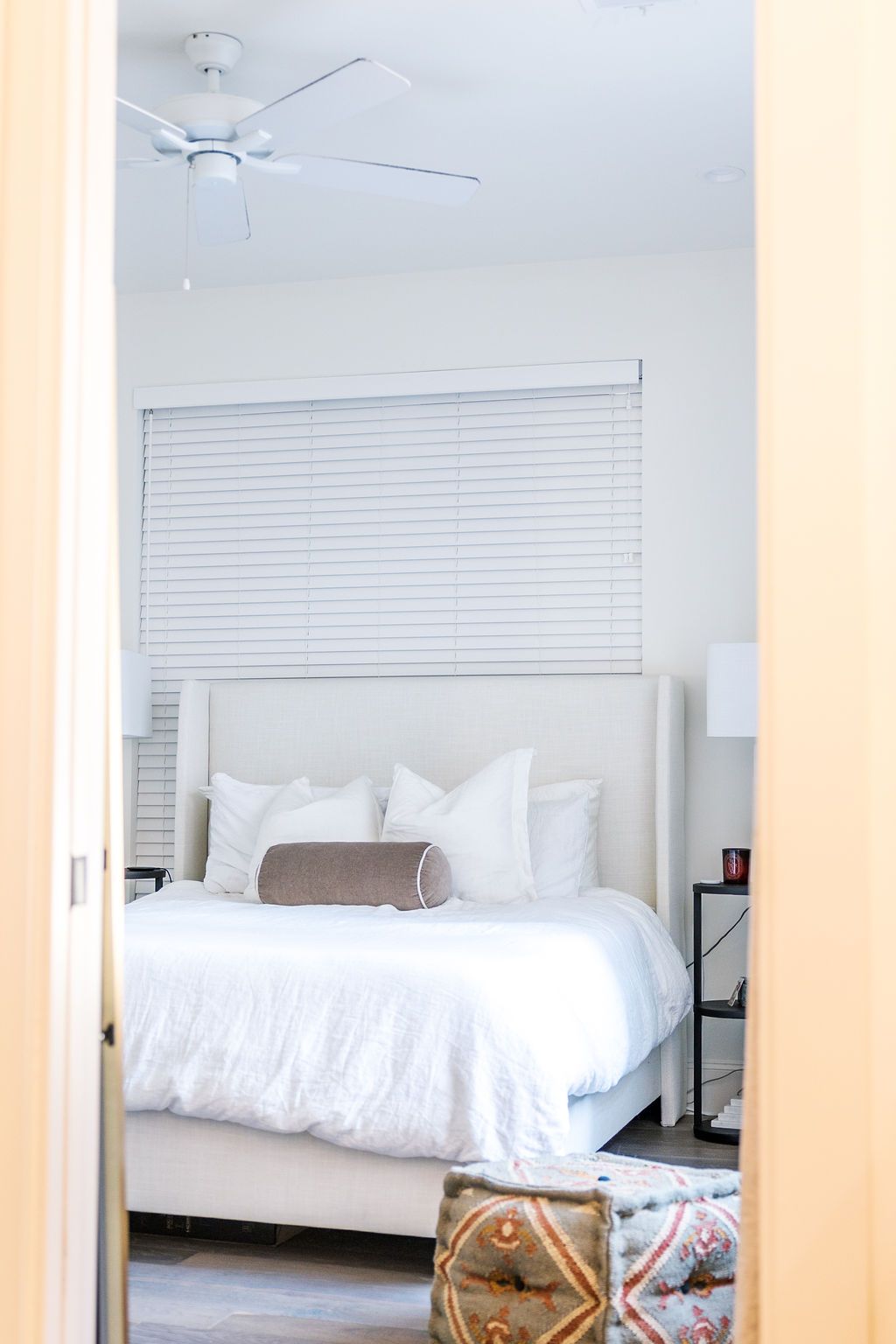 A bedroom with a bed and a ceiling fan.
