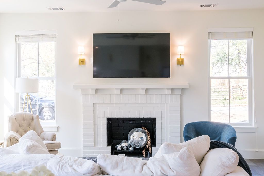A living room with a fireplace and a flat screen tv on the wall.