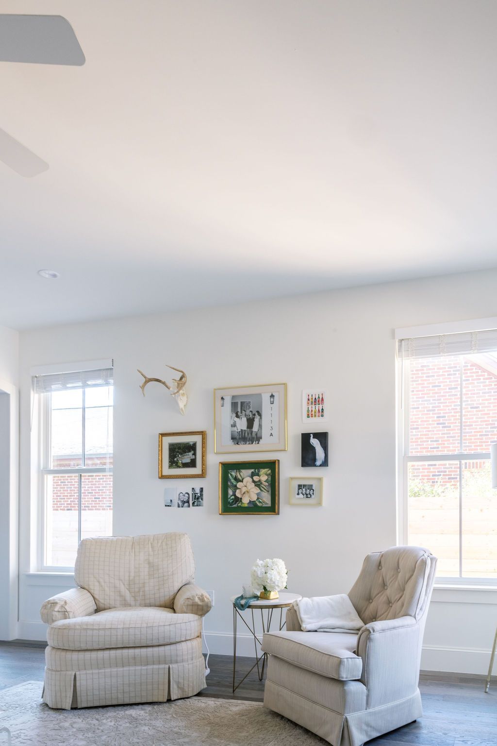A living room with two chairs and a ceiling fan.