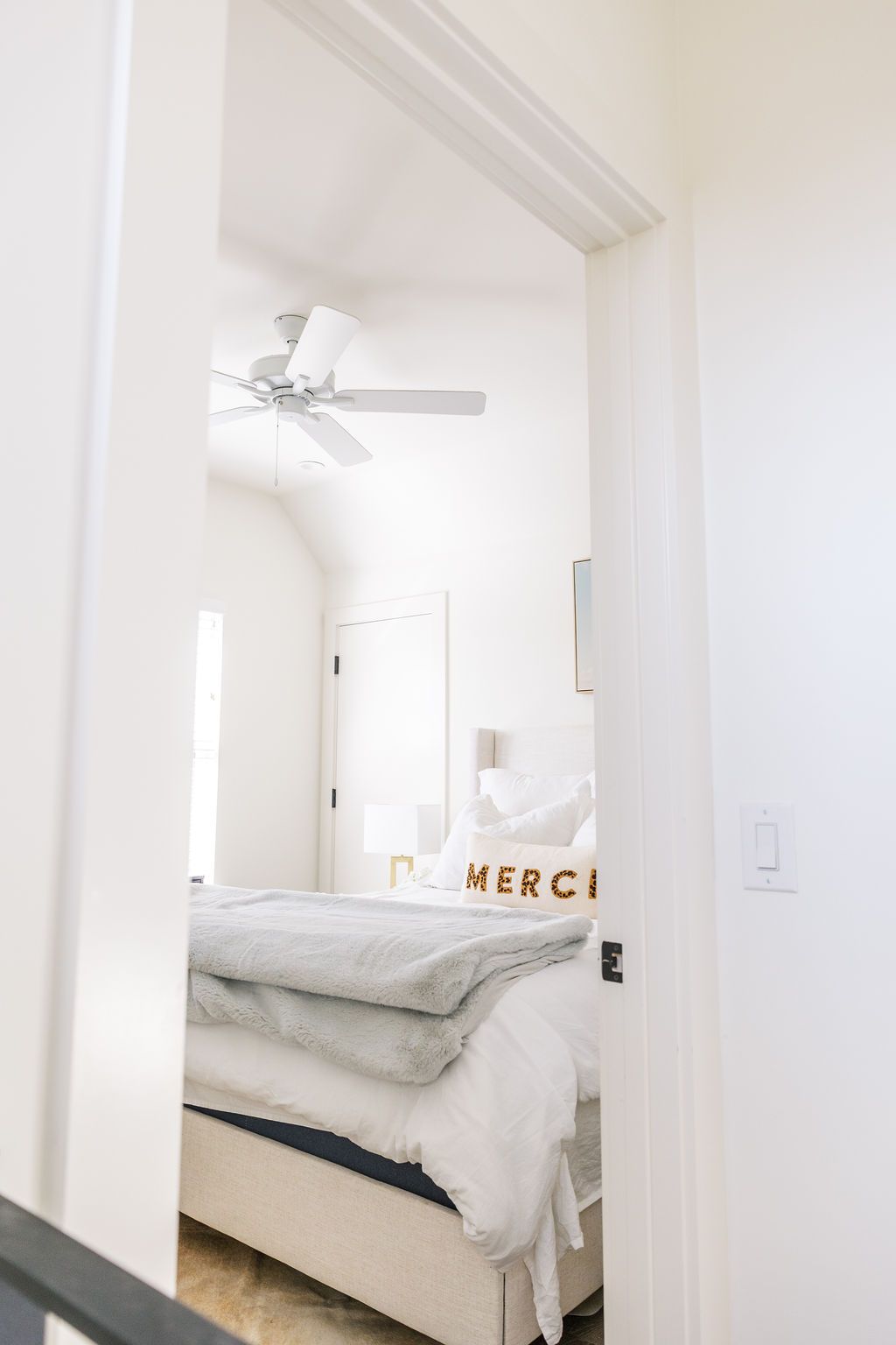 A bedroom with a bed and a ceiling fan.