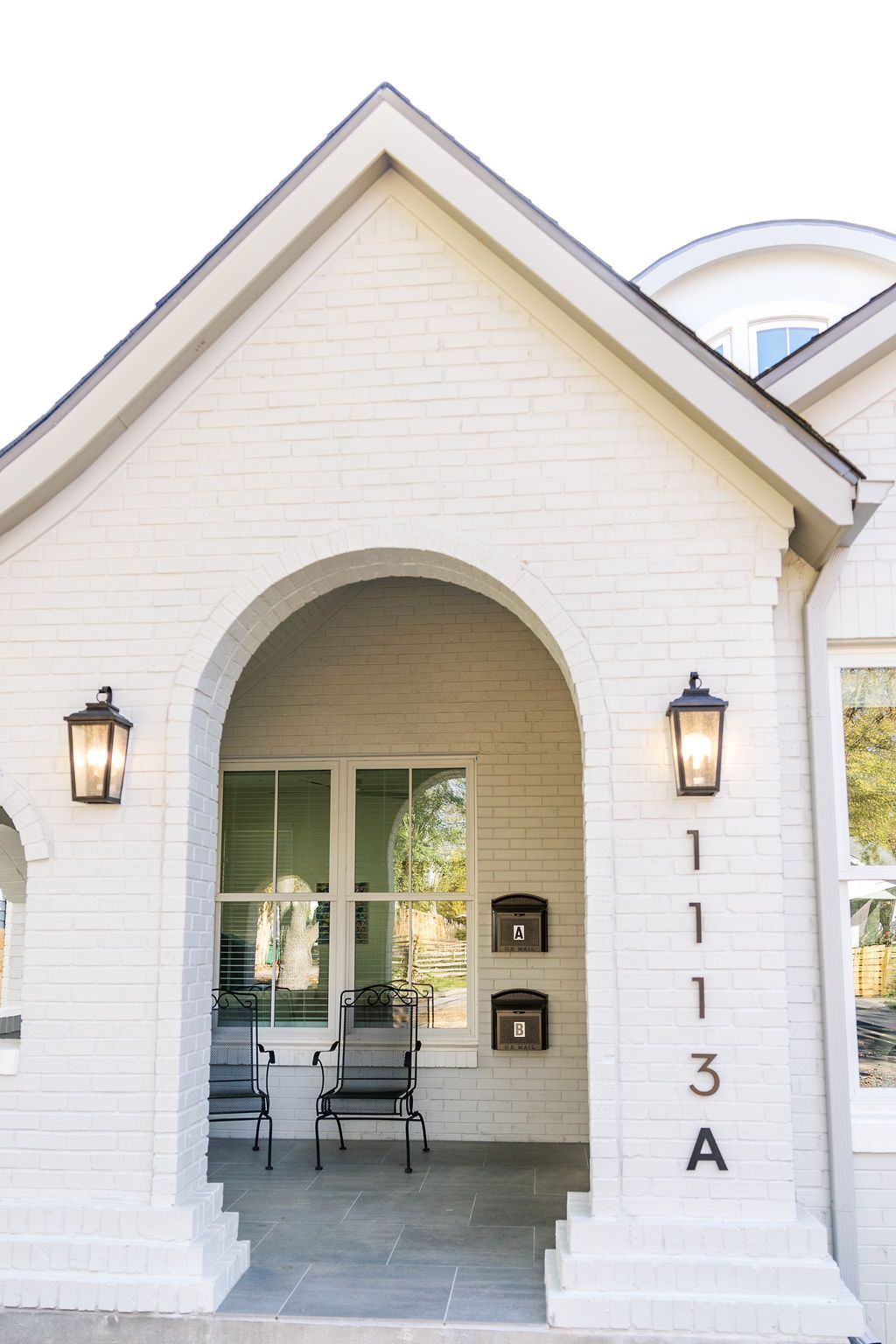 A white brick house with the address 1103 a on the side