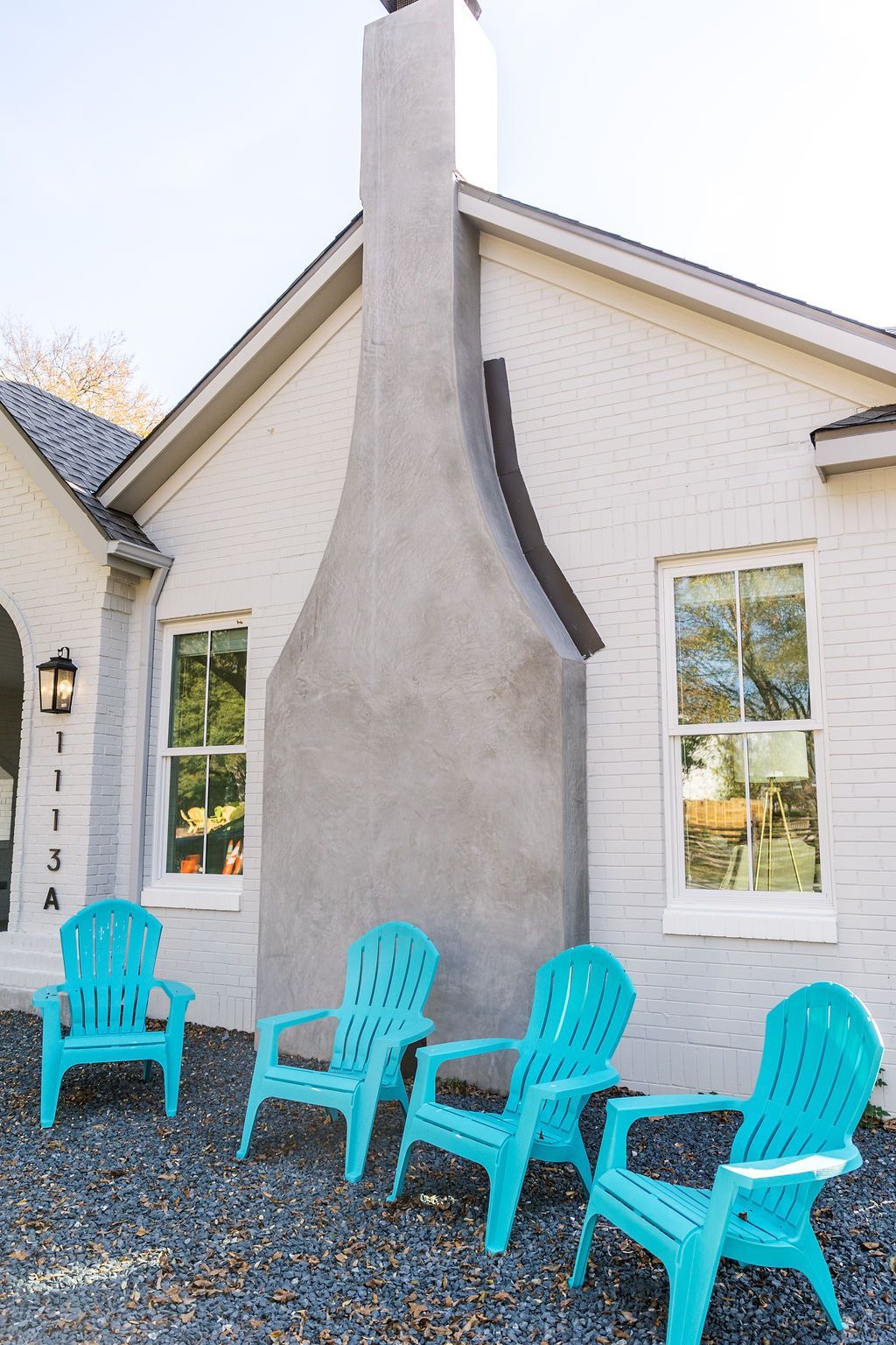 A white house with blue chairs in front of it