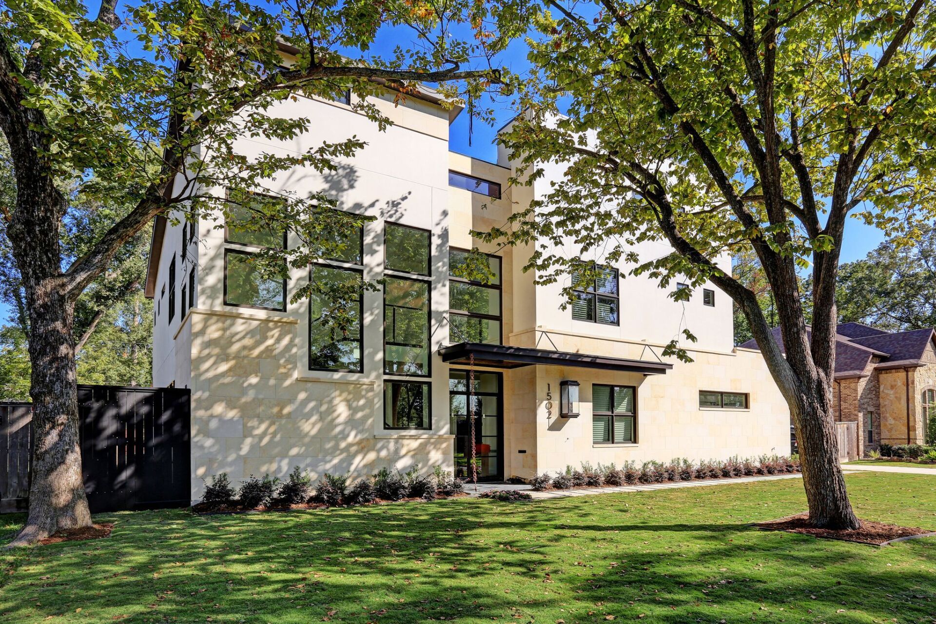 A large white house with a lot of windows and trees in front of it.