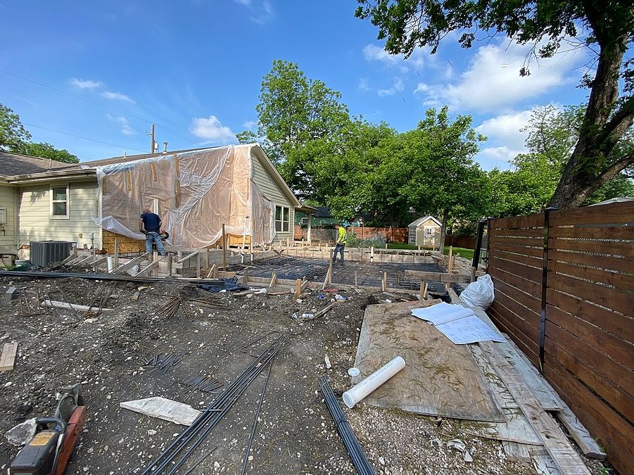 A house is being built in a backyard with a wooden fence.