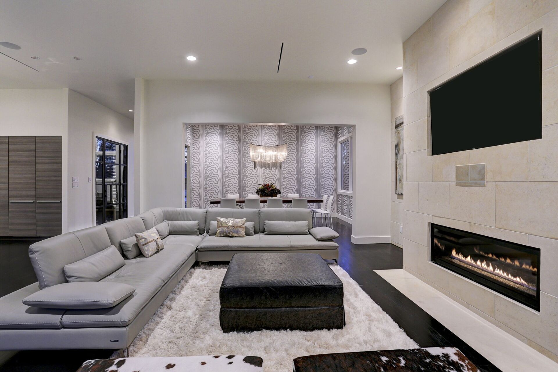 A living room with a large sectional couch and a fireplace