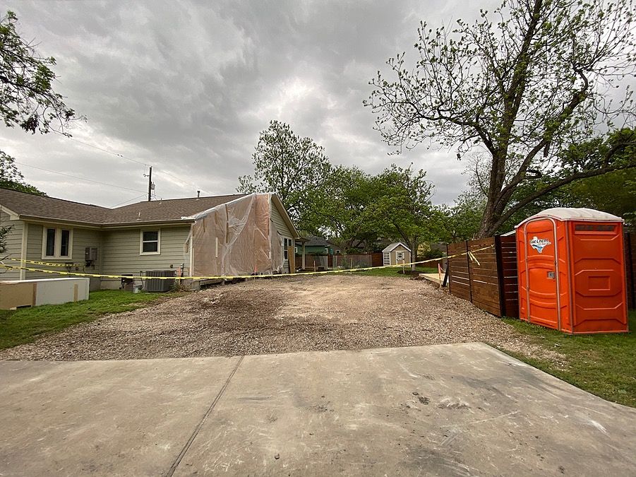 A house with a portable toilet in front of it.