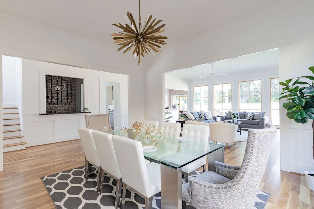 A dining room with a glass table and chairs and a chandelier.