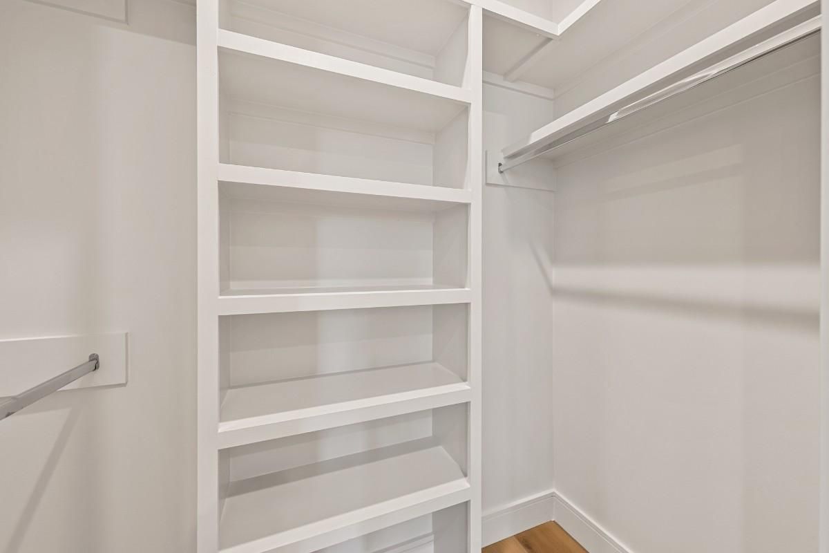 White closet interior with shelves and a hanging rod.