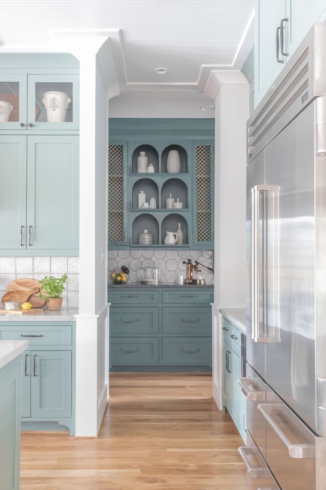 A kitchen with blue cabinets and stainless steel appliances.