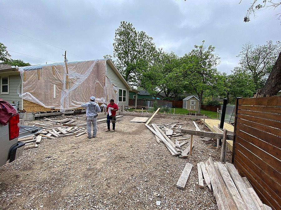 Two men are standing in front of a house that is being built.