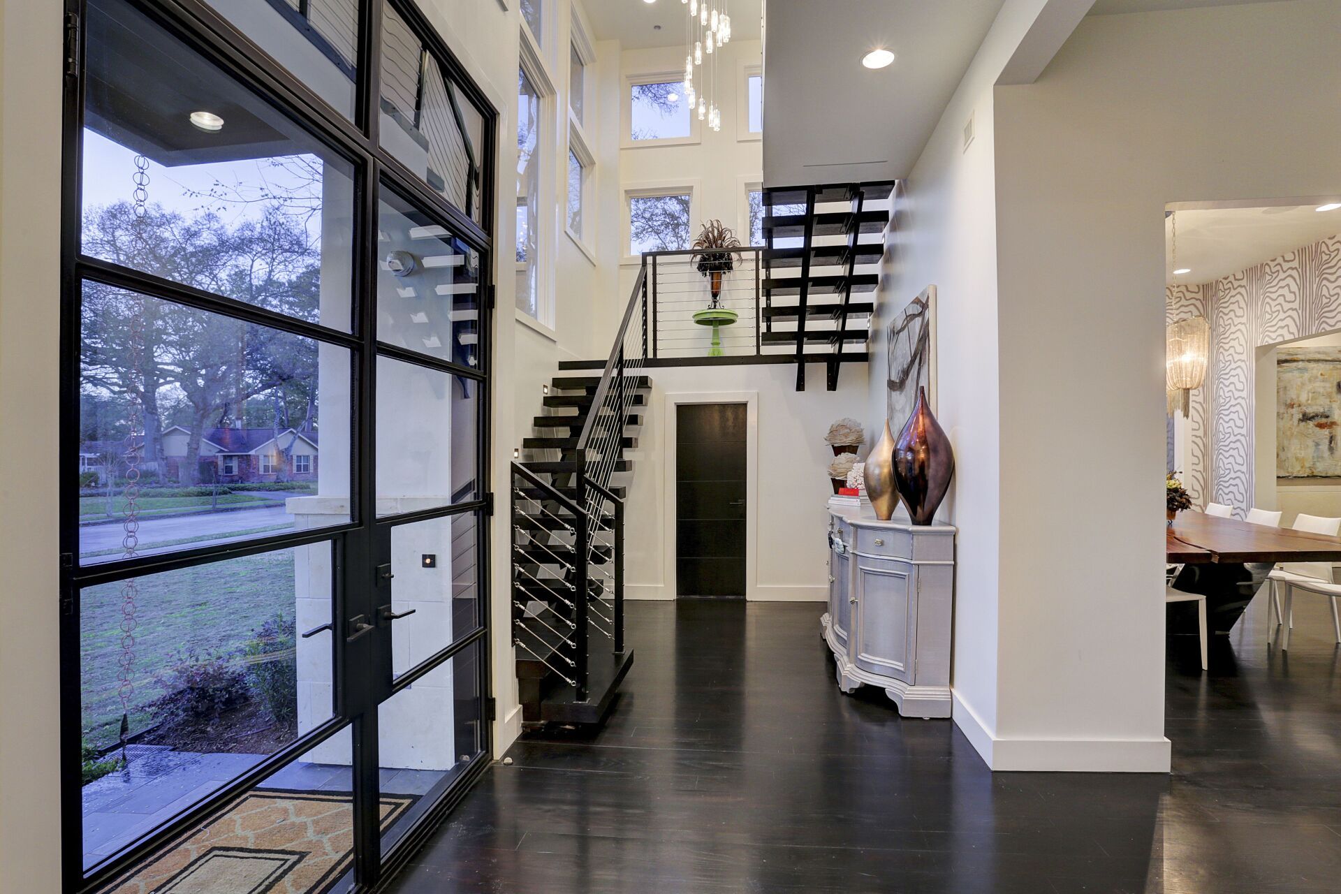 A hallway with a staircase and a glass door