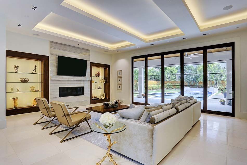 A living room with a couch , chairs , a television and a fireplace.