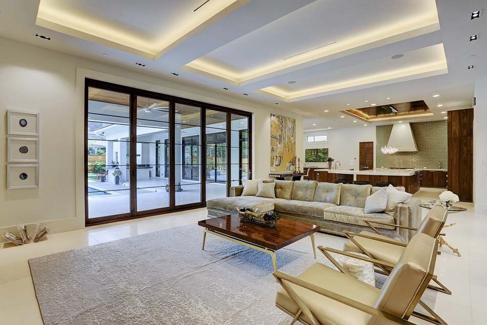 A living room with a couch , chairs , coffee table and sliding glass doors.
