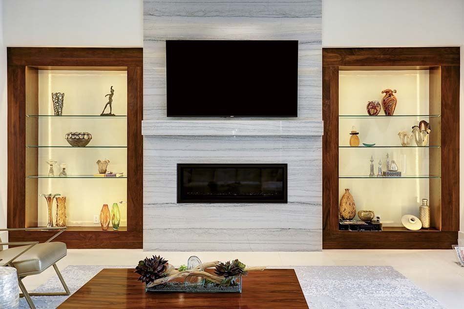 A living room with a fireplace and a flat screen tv on the wall.