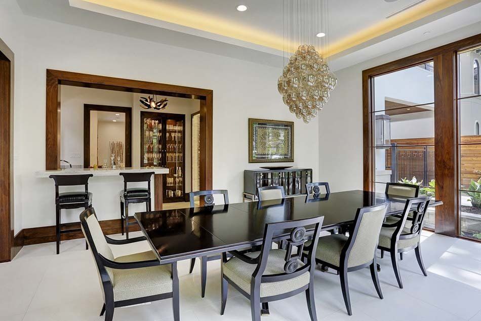 A dining room with a table and chairs and a chandelier hanging from the ceiling.