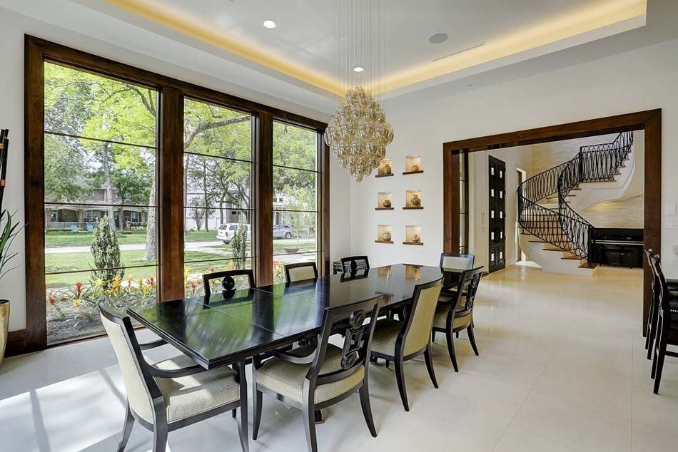 A dining room with a long table and chairs and a chandelier.