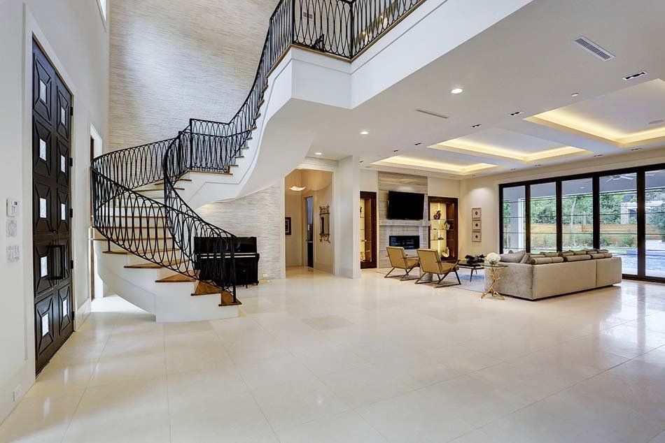 A large living room with a spiral staircase and a piano