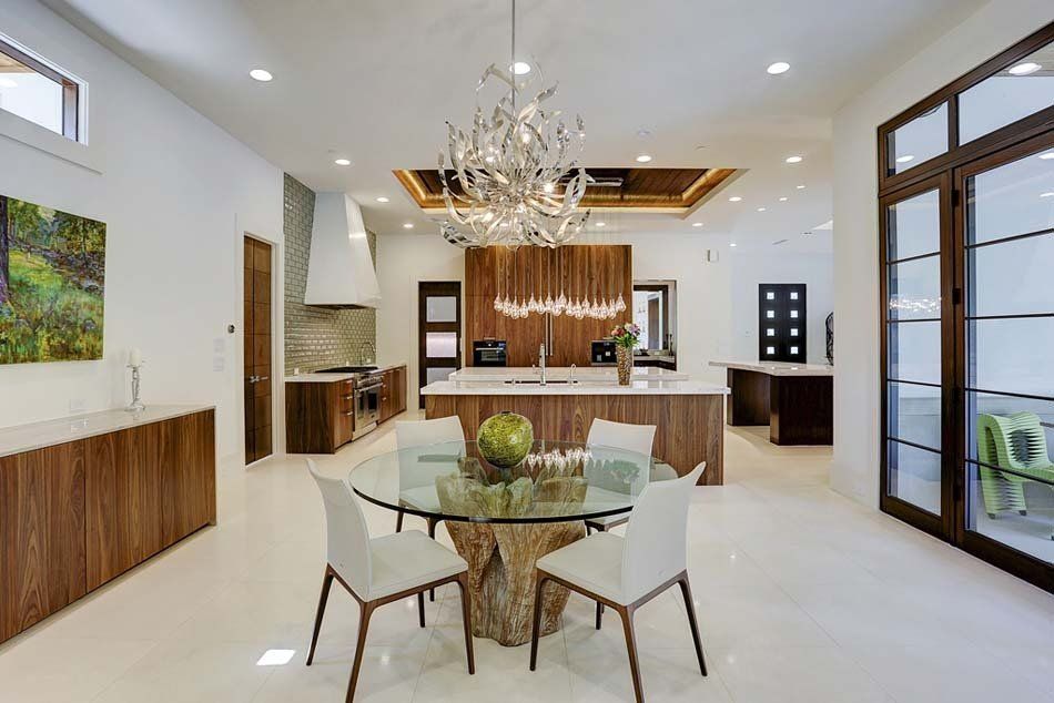 A dining room with a glass table and chairs and a chandelier.