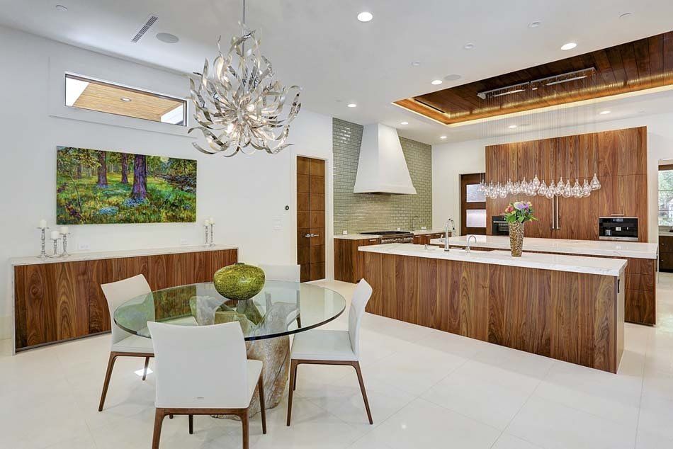 A kitchen with a glass table and chairs and a chandelier.