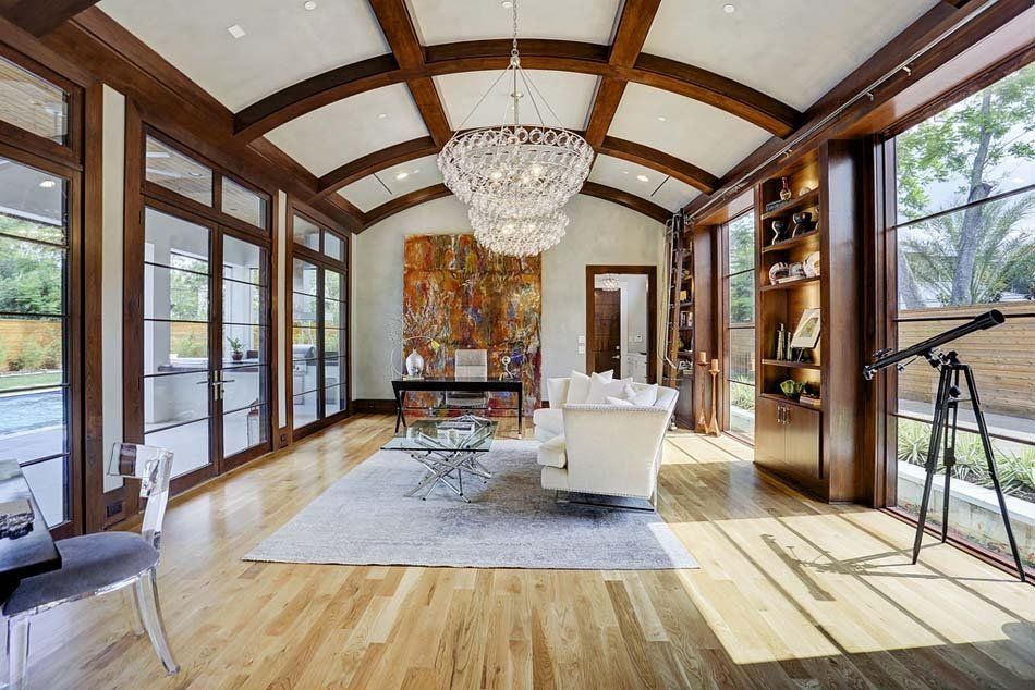 A living room with a lot of windows and a chandelier.