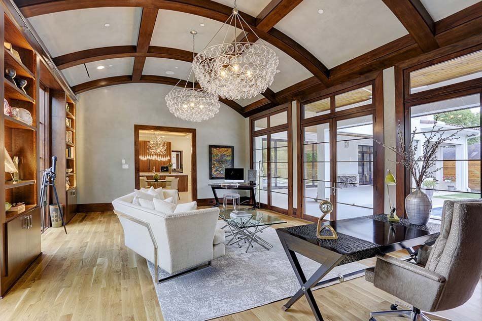 A living room with a couch , desk , chair and lots of windows.