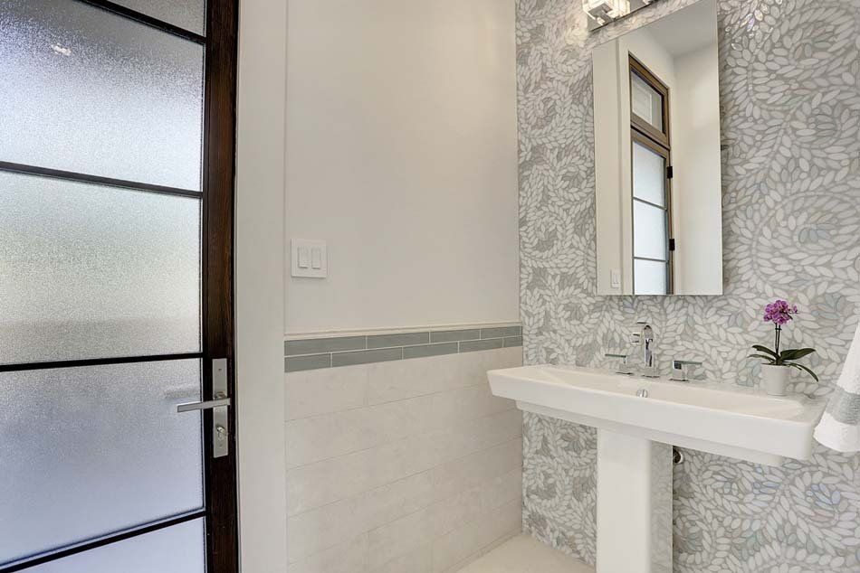 A bathroom with a pedestal sink and a mirror